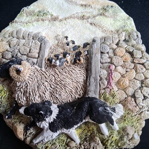 May include: A detailed, textured figurine depicting a sheepdog herding sheep through a stone gate. The sheepdog is black and white, and the sheep are black and white. The background features a stone wall and a grassy hill.
