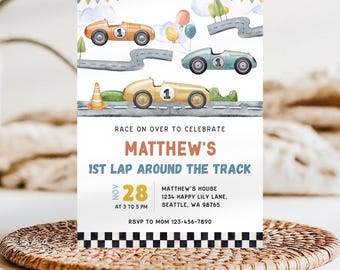 May include: A colorful invitation for a 1st birthday party with a race car theme. The invitation features a watercolor illustration of a race track with three cars, balloons, and a checkered flag. The text on the invitation reads "Race on over to celebrate Matthew's 1st Lap Around the Track" with the date and time of the party.