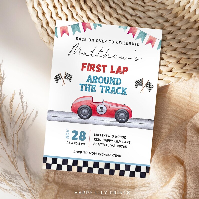 May include: A red, white, and blue race car themed invitation for a first birthday party. The invitation says "Race on over to celebrate Matthew's First Lap Around the Track". The date is November 28th, from 3 to 5 PM. The location is Matthew's house, 1234 Happy Lily Lane, Seattle, WA 98765. RSVP to Mom at 123-456-7890.