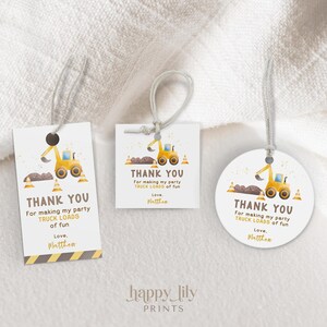 May include: Three white gift tags with a construction theme. Each tag features a yellow excavator, brown dirt, and the text "THANK YOU" with the message "For making my party TRUCK LOADS of fun". The tags are tied with string.