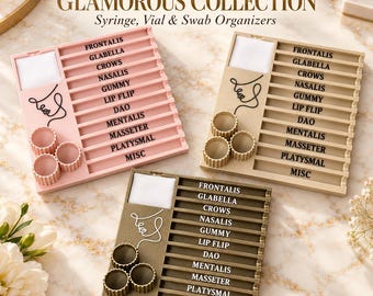 May include: Three square organizers for syringes, vials, and swabs in pink, beige, and dark brown. Each features a line-art face, a white square section, three circular holders, and labeled slots: Frontalis, Glabella, Crows, Nasalis, Gummy, Lip Flip, DAO, Mentalis, Masseter, Platysmal, and Misc.