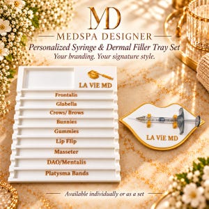 May include: A white rectangular tray with gold text listing facial injection sites including Frontalis, Glabella, Crows/ Brows, Bunnies, Gummies, Lip Flip, Masseter, DAO/Mentalis, and Platysma Bands, alongside a lip-shaped tray holding a syringe.