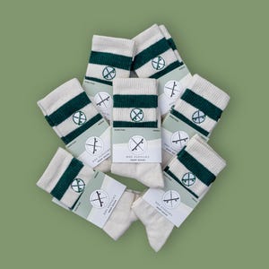 May include: A pile of white and green striped hemp socks with the text "Doc Flossin' Hemp Socks" on the packaging.