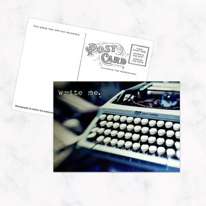 May include: A postcard with a photograph of a vintage typewriter, with the text "Write me." The postcard's back is visible, with space for a message and address. The typewriter is a Smith Corona model.