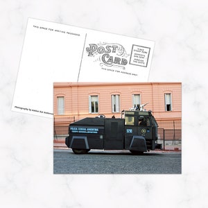 May include: A postcard featuring a photograph of a black armored vehicle with the text "POLICIA FEDERAL ARGENTINA" and the number "9218". The postcard also includes space for a message and address.