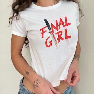May include: White t-shirt with a red graphic of a knife and the text "FINAL GIRL".