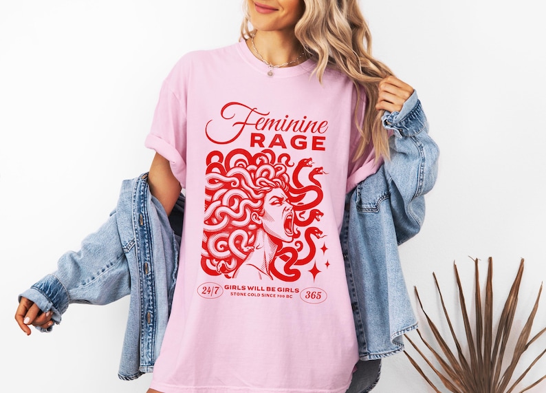 May include: Pink t-shirt with a red graphic of a woman with snakes for hair. The text "Feminine Rage" is above the graphic and "Girls will be girls. Stone cold since 700 BC" is below the graphic.
