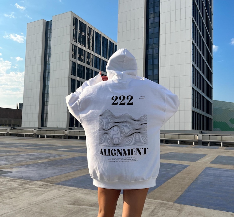 May include: White hoodie with a black and white graphic print on the back. The graphic features a wavy design with the text "222" and "ALIGNMENT" below it.