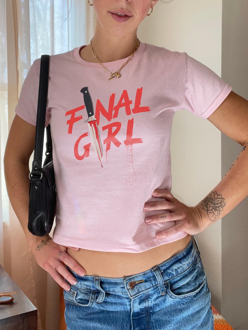 May include: Pink cropped t-shirt with a red graphic of a knife and the text "FINAL GIRL".