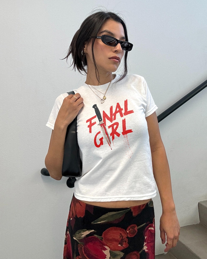 May include: White t-shirt with a red graphic of a knife and the text "FINAL GIRL".