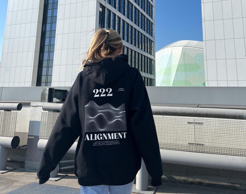 May include: Black hoodie with a graphic design on the back. The design features a wavy pattern with the text "222" and "ALIGNMENT".
