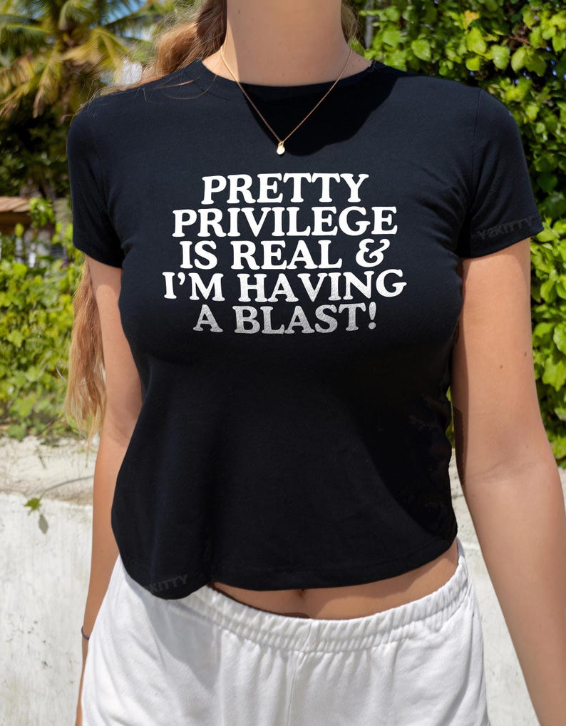 May include: A black cropped t-shirt with the text "PRETTY PRIVILEGE IS REAL & I'M HAVING A BLAST!" printed in white.