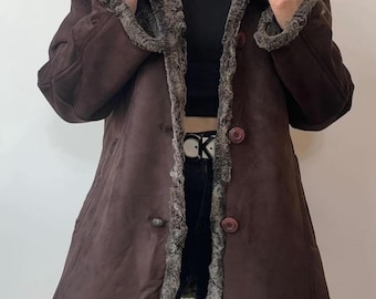May include: A brown suede jacket with a faux fur lining. The jacket has a button closure and a collar.