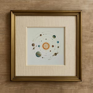 May include: Framed watercolor painting of the solar system. The artwork features a central sun with planets of various colors orbiting around it. The frame is gold-colored, and the artwork is set against a cream-colored mat.