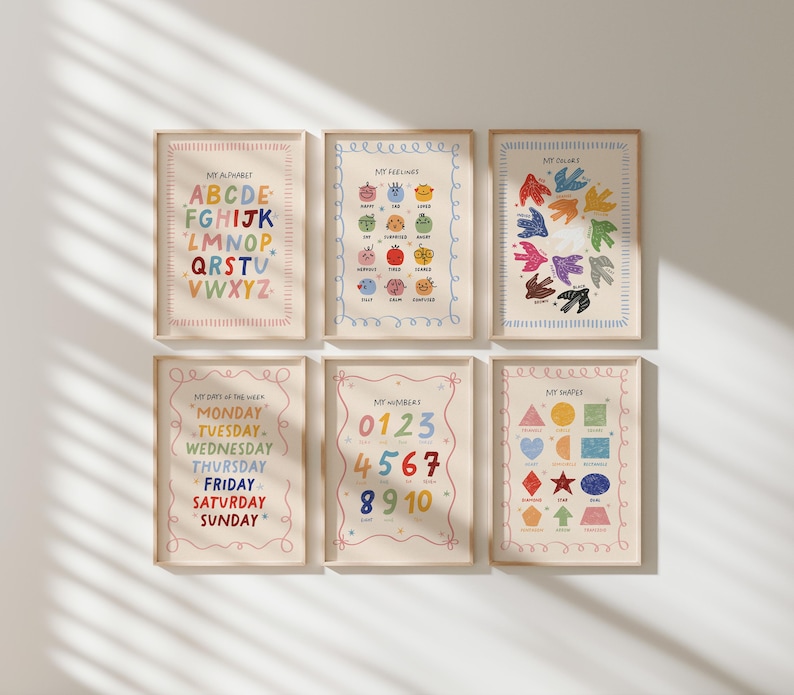 May include: Six framed educational posters with colorful illustrations. The posters display the alphabet, feelings, colors, shapes, numbers, and days of the week. Each poster has a cream-colored background and a wooden frame.