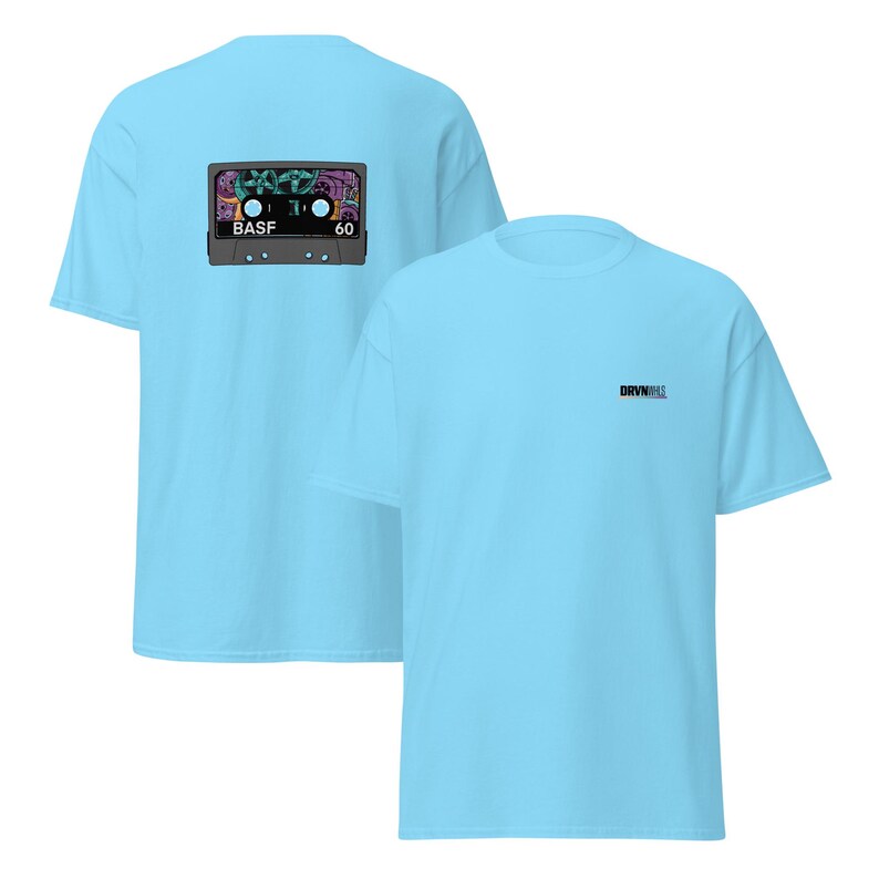 Puede incluir: Camisetas de color azul claro. La parte posterior de la camiseta presenta un gr&aacute;fico de cinta de cassette de colores con "BASF 60". La parte delantera de la camiseta tiene el texto "DRVN" en letras negras peque&ntilde;as.