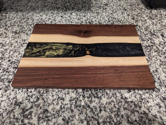 Live-edge oak slab meets flowing epoxy resin rivers — each board is a literally unrepeatable piece of functional wood art.