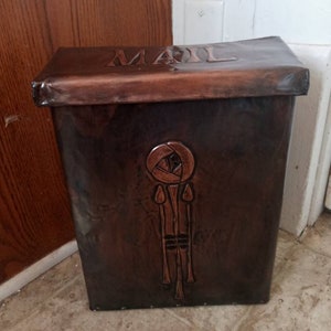 May include: A copper mailbox with a decorative rose design and the word "MAIL" embossed on the top.