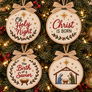 May include: Four round embroidery hoop ornaments featuring off-white fabric with festive stitching. Designs include text reading Oh Holy Night, Christ Is Born, The Birth of a Savior, and a nativity scene, all accented with burlap bows and stars.