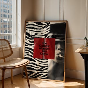 May include: A rectangular framed wall art print featuring a split design. The left side displays a black and white zebra stripe pattern. The right side shows a black and white portrait of a person with a cigarette, overlaid with a red square containing the black text The Coolest Woman You Know.
