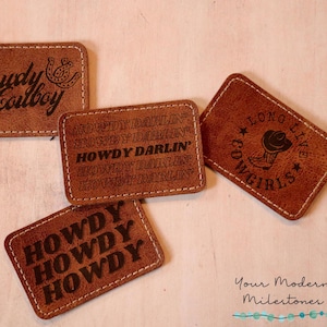 May include: Four brown leather patches with stitched edges. The patches feature different western-themed designs, including the text "Howdy Darlin'" and a cowboy boot with a star.