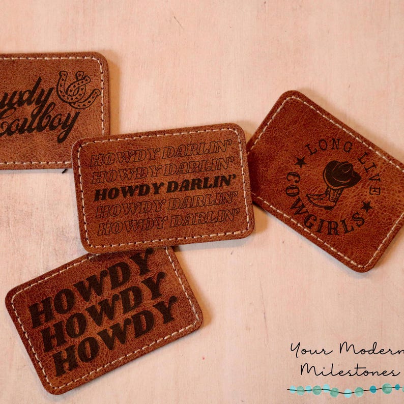 May include: Four brown leather patches with stitched edges. The patches feature different western-themed designs, including the text "Howdy Darlin'" and a cowboy boot with a star.