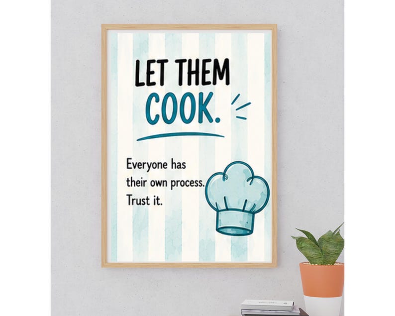 May include: A framed wall art print featuring vertical light blue and white stripes. The text reads "LET THEM COOK." followed by "Everyone has their own process. Trust it." A light blue chef hat illustration is positioned on the lower right side.