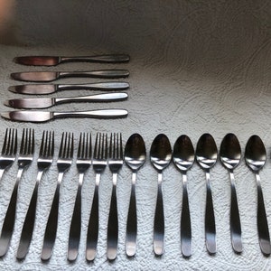 May include: A set of silverware, including eight forks, eight spoons, and four knives, all made of stainless steel.