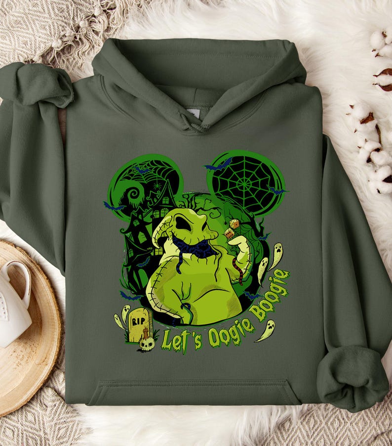 May include: Dark green hoodie featuring a graphic of Oogie Boogie from The Nightmare Before Christmas. The design includes a green Oogie Boogie, bats, ghosts, and the text "Let's Oogie Boogie". The design is set against a green Mickey Mouse silhouette.