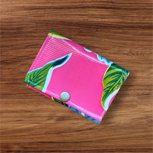 Cartera de tres pliegues con estampado floral en tela oleosa de color rosa