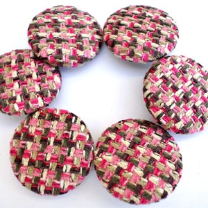 May include: Six round fabric buttons in a pink, brown, and white tweed pattern.