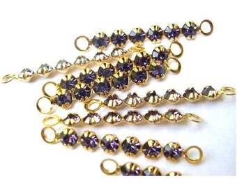 May include: A set of seven gold chains with purple rhinestones. Each chain has a loop at each end for attaching to other jewelry or crafts.