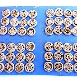 May include: A sheet of blue cardstock with 48 round, beige buttons with a woven design. The buttons are arranged in rows of 6.