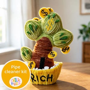 Op de afbeelding: Een handgemaakte pijpenragerkit in de vorm van een geldboom, met groene bladeren, een bruine stam en gele dollartekens. De boom staat in een gele pot met het woord "RICH" geborduurd. De kit bevat de tekst "Pipe cleaner kit" en het "CHILL FUZZ"-logo.