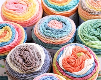 Könnte beinhalten: Eine Sammlung bunter Wollknäuel in verschiedenen Farbtönen, darunter Rosa, Gelb, Blau und Grün. Das Garn ist in einem Spiralmuster angeordnet, was eine ansprechende Darstellung ergibt. Ideal für Strick- und Häkelprojekte.