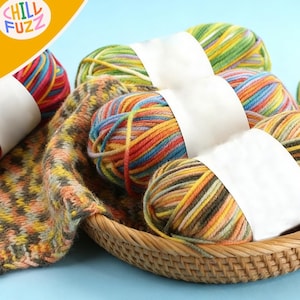 May include: A wicker basket filled with colorful yarn balls and a knitted scarf. The yarn is a mix of red, orange, yellow, green, and blue. The scarf has a patterned design with similar colors. The text "CHILL FUZZ" is in the upper left corner.