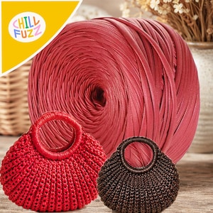 Könnte beinhalten: Eine große Spule mit rotem Bändchengarn hinter zwei kleinen, runden, gehäkelten Handtaschen. Eine Handtasche ist leuchtend rot, die andere dunkelbraun. Beide Taschen haben kreisförmige Griffe und ein strukturiertes Rippenstrickmuster.