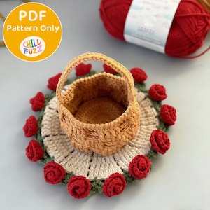 May include: A crocheted basket with a handle sits on a round doily decorated with red crocheted roses. The doily is beige with a green border. The basket is light brown. The image includes a ball of red yarn and a yellow circle with the text "PDF Pattern Only" and "Chill Fuzz".