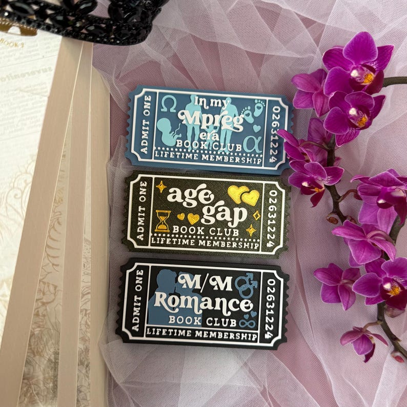 K&ouml;nnte beinhalten: Drei rechteckige Mitgliedskarten f&uuml;r Buchclubs mit schwarzen R&auml;ndern und wei&szlig;em Text. Die Karten haben verschiedene Themen: "In my Mpreg era", "age gap" und "M/M Romance". Jede Karte hat ein einzigartiges Design und den Text "Lifetime Membership".