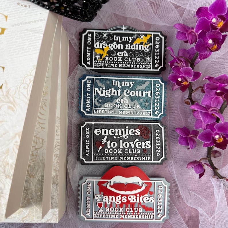 K&ouml;nnte beinhalten: Vier ticketf&ouml;rmige Mitgliedskarten f&uuml;r einen Buchclub mit einzigartigen Designs und Texten. Die Karten zeigen S&auml;tze wie "In my dragon riding era" und "Fangs Bites Book Club". Der Hintergrund umfasst ein Buch, Orchideen und dekorative Elemente.