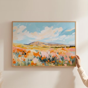 May include: A framed abstract painting depicting a field of orange, pink, and yellow flowers with a blue sky and white clouds in the background. The painting has a light and airy feel.