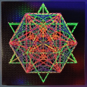 May include: A colorful geometric design created with string art. The design features a star shape with multiple layers of string in shades of green, purple, red, and orange.
