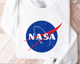 May include: White sweatshirt with a blue and red NASA logo printed on the front.