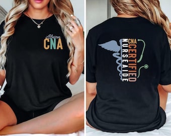 May include: Black t-shirt with the text "Certified CNA Nurse Aide" and a caduceus symbol on the back. The front of the shirt has the text "Alaina CNA" in colorful letters.