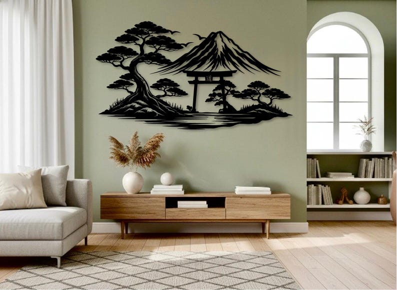 May include: Black metal wall art depicting a Japanese landscape with Mount Fuji, trees, and a torii gate. The artwork is mounted on a light green wall above a wooden media console. The room has a modern, minimalist aesthetic.