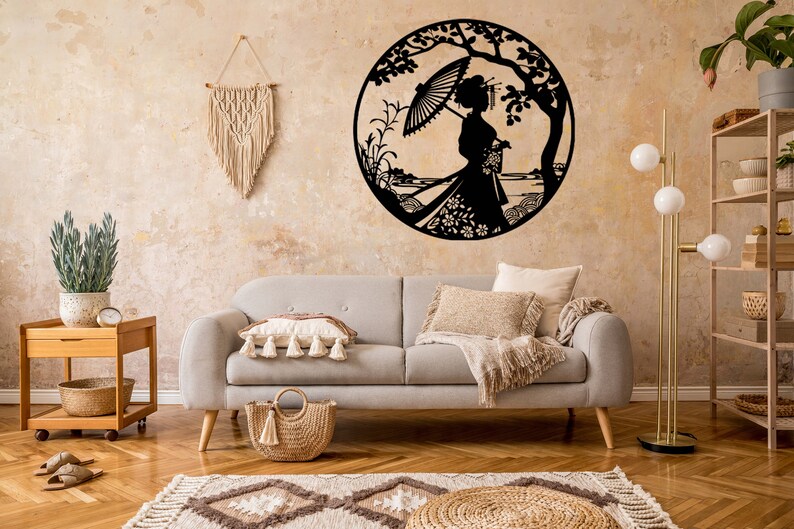 May include: A gray couch with a throw blanket and pillows sits in a living room with a wooden side table, a woven basket, and a floor lamp. A black metal wall decor featuring a woman with an umbrella and flowers is on the wall behind the couch.