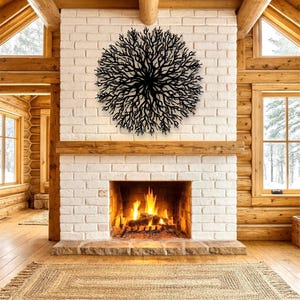 May include: A black metal tree branch wall art decor is mounted on a white brick fireplace. The fireplace has a burning fire inside. The room has wooden beams and windows.