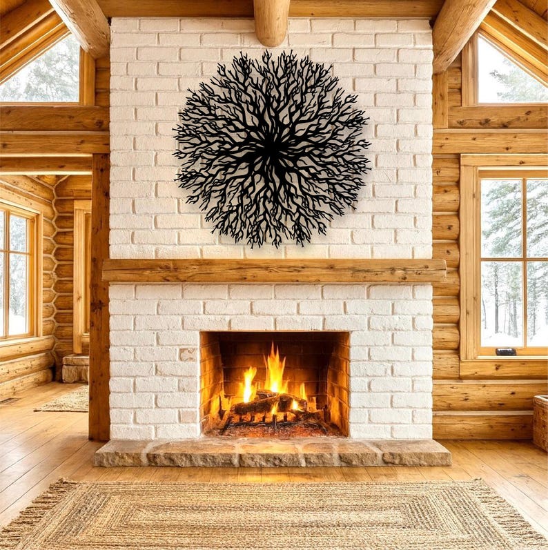 May include: A black metal tree branch wall art decor is mounted on a white brick fireplace. The fireplace has a burning fire inside. The room has wooden beams and windows.