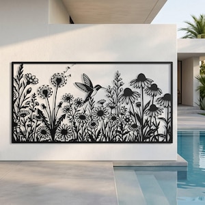 May include: A rectangular black metal wall art piece featuring a laser-cut design of a hummingbird hovering among various wildflowers, including dandelions and daisies, enclosed within a thin, solid black frame border.