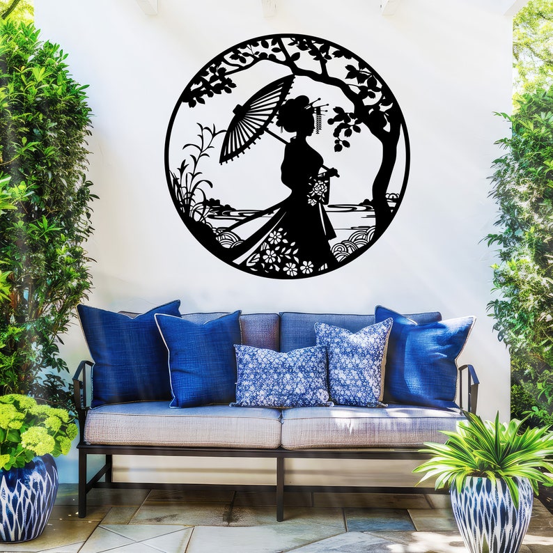 May include: Black metal wall art featuring a silhouette of a woman in a kimono holding an umbrella, standing in front of a tree and a body of water. The art is circular and has a decorative design.